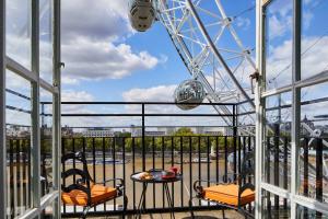 Una noria con 2 sillas y una mesa en el balcón en London Marriott Hotel County Hall, en Londres