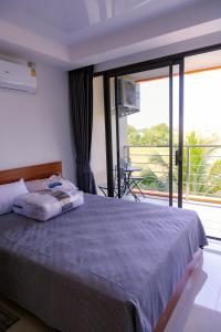 a bedroom with a bed and a large window at 777 Beach Condo Phuket in Mai Khao Beach