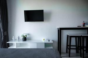 a bedroom with a white table with a tv on the wall at 777 Beach Condo Phuket in Mai Khao Beach