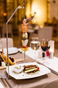 a plate of food on a table with wine glasses at Prive Hotel Bodrum - Adult Only in Bodrum City