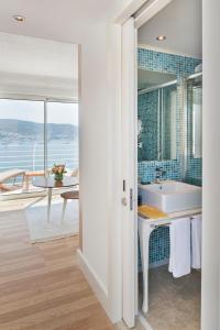 Prive Hotel Bodrum - Adult Only في بودروم: حمام مع حوض استحمام وإطلالة على المحيط
