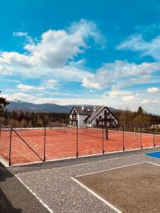 an empty tennis court with a tennis courtermottermottermott at Kazalnica Family&Conference Resort in Sosnówka