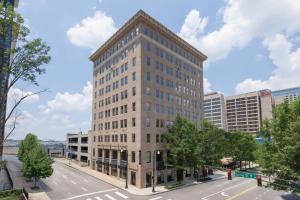 een hoog wit gebouw in een stadsstraat met bomen bij Glenn Hotel, Autograph Collection in Atlanta