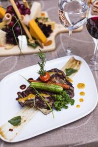 a plate of food with vegetables and a glass of wine at Prive Hotel Bodrum - Adult Only in Bodrum City