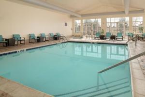 a large swimming pool with chairs and tables at Residence Inn Bozeman in Bozeman