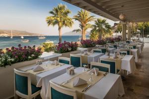 a restaurant with tables and the ocean in the background at Prive Hotel Bodrum - Adult Only in Bodrum City