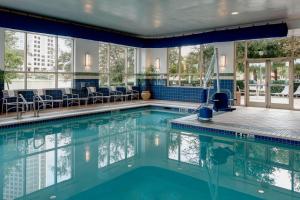 una piscina con sedie e tavoli in un edificio di Marriott Dallas Las Colinas a Irving