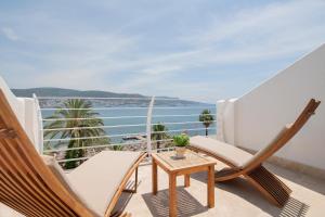 a balcony with chairs and a table and the ocean at Prive Hotel Bodrum - Adult Only in Bodrum City