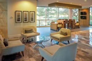 a lobby with chairs and a table and a dining room at Ann Arbor Marriott Ypsilanti at Eagle Crest in Ann Arbor