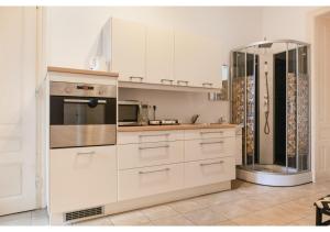 a kitchen with white cabinets and a refrigerator at Super helles Apartment - perfect for Longstays in Vienna