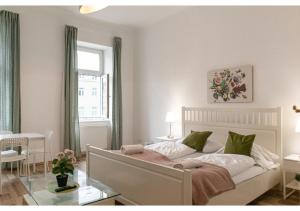 a bedroom with a white bed with green pillows at Super helles Apartment - perfect for Longstays in Vienna