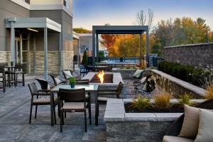 a patio with tables and chairs and a fire pit at Courtyard by Marriott Albany Airport in Albany