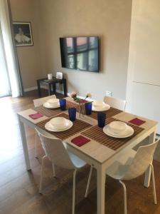 a dining room table with white plates and chairs at Morivione Apartment - Bocconi free parking in Milan