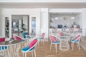 a dining room with tables and chairs with pink and blue cushions at Prive Hotel Bodrum - Adult Only in Bodrum City