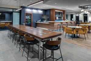 a restaurant with a large wooden table and chairs at Courtyard by Marriott Jefferson City in Jefferson City