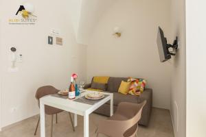uma sala de estar com uma mesa e um sofá em [Alibi Suites] Suite Fieramosca Spa & Relax em Ruvo di Puglia