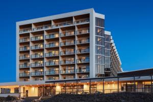 een groot hotelgebouw met lichten aan bij Delta Hotels by Marriott Virginia Beach Waterfront in Virginia Beach