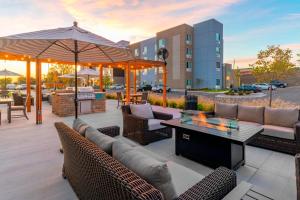 a patio with couches and a table and an umbrella at TownePlace Suites by Marriott Leavenworth in Leavenworth
