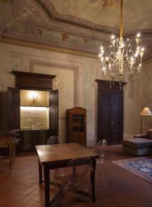 a dining room with a table and chairs and a chandelier at Renaissance Palace Noble Floor Apartment in Florence