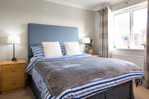 a bedroom with a large bed with two pillows at Waters Edge - stylish marina retreat in Pevensey