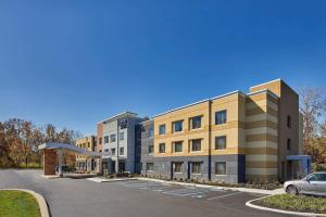 an apartment building with a car parked in a parking lot at Fairfield Inn & Suites by Marriott Albany Airport in Albany