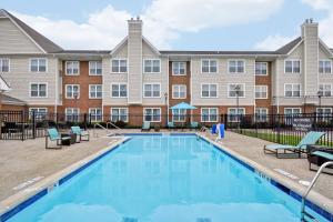 a swimming pool with chairs and a building at Residence Inn Lexington South Hamburg Place in Lexington