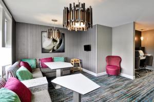 a living room with a couch and pink chairs at Residence Inn Lexington South Hamburg Place in Lexington