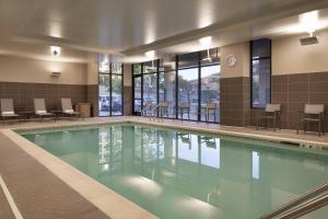 a swimming pool in a building with chairs and tables at Residence Inn Walnut Creek in Walnut Creek