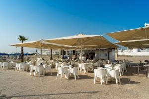 een groep tafels en stoelen met parasols bij Isola di Albarella in Isola Albarella