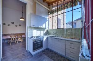 cocina con armarios blancos y fogones en Villa Ada Historic 800s, en Mandello del Lario