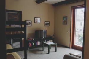 a living room with a tv and a table and a window at Tettoeletto Garden Bio in Castellammare di Stabia