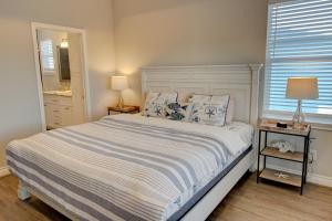 una camera con un letto, due lampade e una finestra di Beachview 2 Story Home with 4 Decks a Galveston