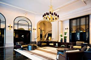 a hotel lobby with a chandelier and chairs at Prince de Galles, a Luxury Collection hotel, Paris in Paris