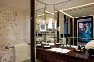 a bathroom with a sink and a large mirror at Prince de Galles, a Luxury Collection hotel, Paris in Paris