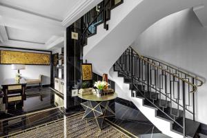eine Treppe in einem Wohnzimmer mit einem Tisch in der Unterkunft Prince de Galles, a Luxury Collection hotel, Paris in Paris