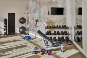 a room with a gym with a treadmill and a tv at SpringHill Suites Charlotte at Carowinds in Charlotte