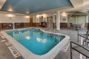 a pool in a hotel with tables and chairs at Fairfield Inn & Suites Warsaw in Warsaw
