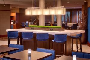 a restaurant with a bar with blue chairs and tables at Courtyard by Marriott Kansas City Shawnee in Shawnee
