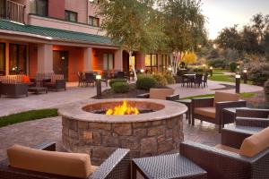 a fire pit in a courtyard with tables and chairs at Courtyard by Marriott Kansas City Shawnee in Shawnee
