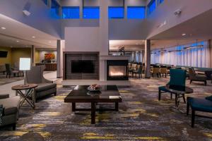 un vestíbulo con chimenea, mesas y sillas en SpringHill Suites by Marriott Fishkill, en Fishkill