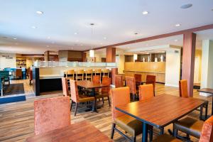 a restaurant with wooden tables and chairs and a bar at TownePlace Suites by Marriott Fort Mill at Carowinds Blvd in Fort Mill