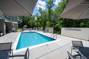 a swimming pool with chairs and an umbrella at TownePlace Suites by Marriott Fort Mill at Carowinds Blvd in Fort Mill