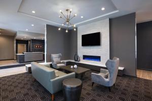 歐文的住宿－TownePlace Suites by Marriott Dallas DFW Airport North/Irving，客厅配有桌椅和电视。