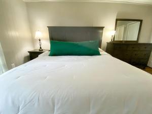a large white bed with a green pillow on it at Beech Please Cozy Beech Mountain Stay in Beech Mountain