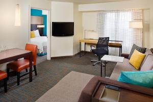 a hotel suite with a living room and a bedroom at Residence Inn by Marriott Detroit Livonia in Livonia