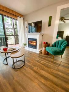 a living room with a green chair and a fireplace at Beech Please Cozy Beech Mountain Stay in Beech Mountain