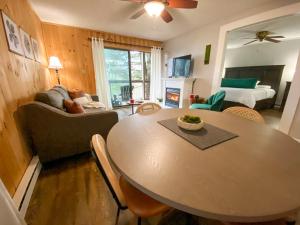 a living room with a table and a bedroom at Beech Please Cozy Beech Mountain Stay in Beech Mountain