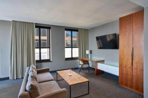 a living room with a couch and a table at Renaissance Saint Elm Dallas Downtown Hotel in Dallas