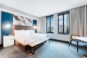 une chambre d'hôtel avec un lit et une table dans l'établissement Renaissance Saint Elm Dallas Downtown Hotel, à Dallas