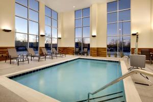 uma piscina no átrio do hotel com cadeiras e mesas em Fairfield by Marriott Inn & Suites Franklin Cool Springs em Franklin